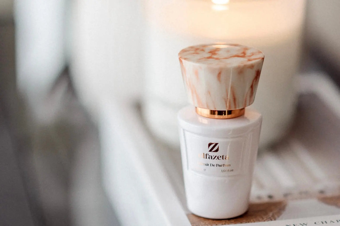 weißer Olfazeta Flakon mit Kerze im Hintergrund